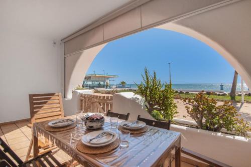 a table on the balcony with a view of the beach at Primera Linea en Matalascañas in Matalascañas
