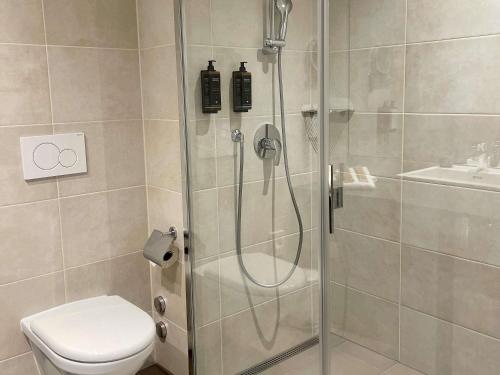a bathroom with a shower with a toilet and a sink at Mercure Geneva Airport in Geneva