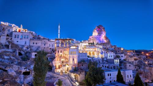 a group of buildings on a mountain at night at Anjelic Cave Cappadocia in Urgup
