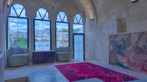 a large room with windows and a red rug at Anjelic Cave Cappadocia in Urgup