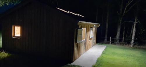 a small wooden building with a door at night at B&B Domaine du Vieux Chêne in Stoumont
