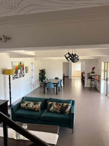 a living room with a green couch and a dining room at SM Exclusive Accommodation in Durban