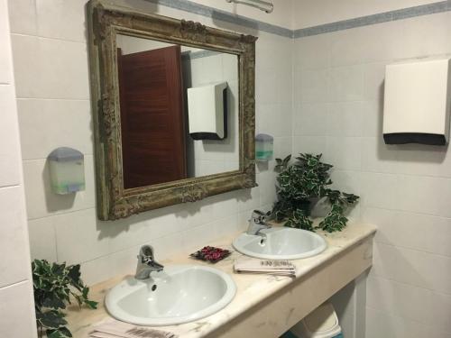 a bathroom with two sinks and a mirror at Hotel Minerva in Pordenone