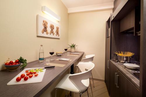 a kitchen with a counter with a table and chairs at CHC Business Residence in Genova