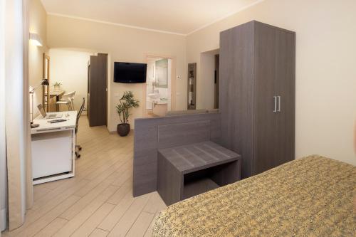 a hotel room with a bed and a desk and a bathroom at CHC Business Residence in Genova