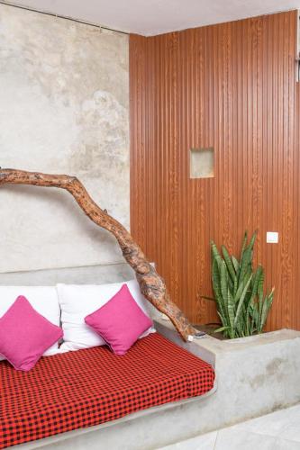 a bed with three pillows sitting on top of it at Couzy stylish stays 3 Bdrm Watamu with Beach access in Watamu