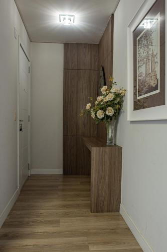 a hallway with a vase of flowers on a table at Melhor Apartamento centro Pomerode, perto de tudo in Pomerode
