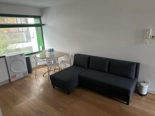 a living room with a black couch and a table at Mulligan Hotel in Dublin
