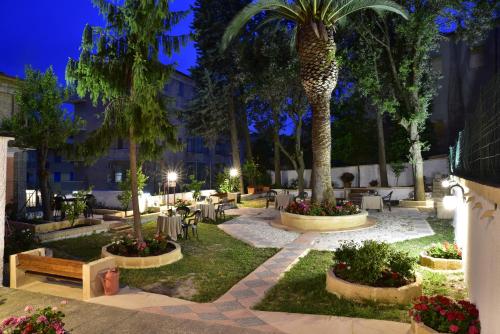 cortile con tavoli e palme di notte di San Gabriele a Loreto