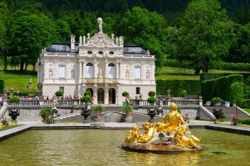 a building with a statue in the water in front at Hotel Krone Tirol in Reutte