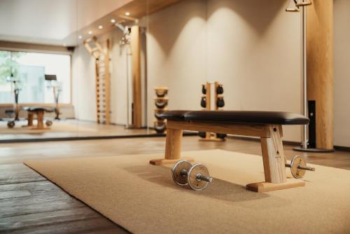 a bench sitting on a rug in a room at Hotel B&B Feldmessner in Brunico