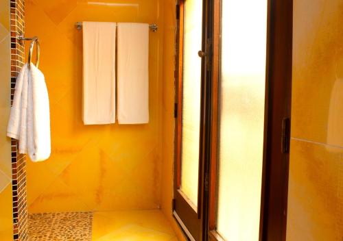a bathroom with a shower with a towel and a window at Hôtel La Villa Racine in Dakar