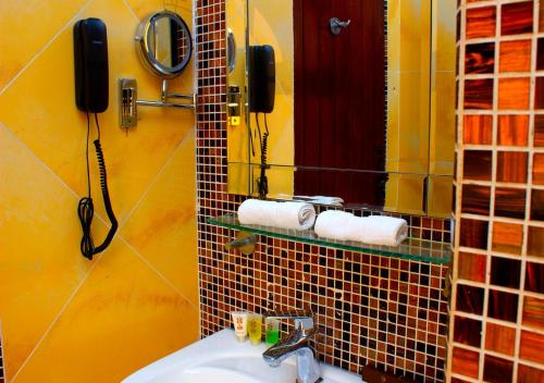 a bathroom with a sink and a phone on the wall at Hôtel La Villa Racine in Dakar
