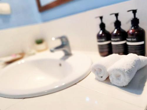a bathroom sink with two rolls of toilet paper on a counter at Oasi Bungalow Gili Air in Gili Islands