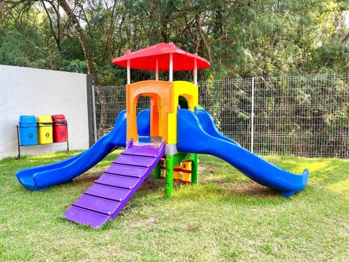 a playground with a slide on the grass at Apartamento Inteiro - 2 Quartos com AC - Wifi 1000mb - Piscina - 1 Vaga de Garagem - Elevador - Sacada Gourmet - Indicado para Grupos, Hospedes a Trabalho, Família e Pets in Toledo