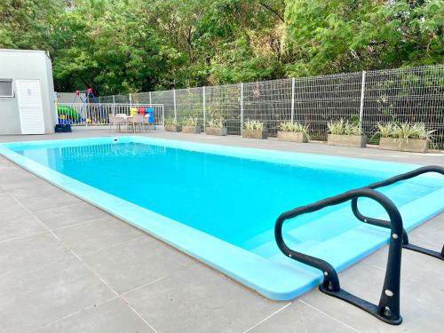 a large blue swimming pool with a black rail around it at Apartamento Inteiro - 2 Quartos com AC - Wifi 1000mb - Piscina - 1 Vaga de Garagem - Elevador - Sacada Gourmet - Indicado para Grupos, Hospedes a Trabalho, Família e Pets in Toledo