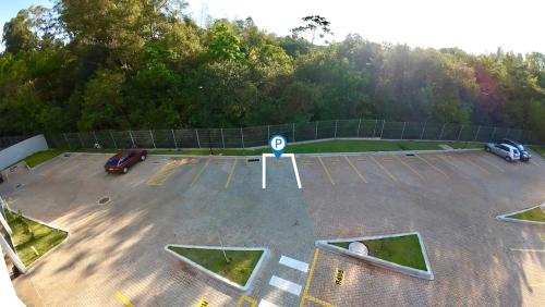 an aerial view of a parking lot with cars at Apartamento Inteiro - 2 Quartos com AC - Wifi 1000mb - Piscina - 1 Vaga de Garagem - Elevador - Sacada Gourmet - Indicado para Grupos, Hospedes a Trabalho, Família e Pets in Toledo