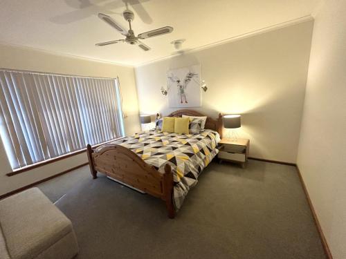 ein Schlafzimmer mit einem Bett und einem Deckenventilator in der Unterkunft Dukes of Yorkes - Wallaroo Beach Frontage - Entire Home in Wallaroo