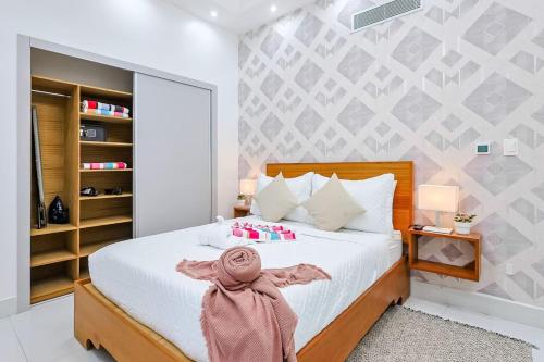a bedroom with a white bed with a pink scarf on it at Upscale Condo, Spectacular Views in Santo Domingo
