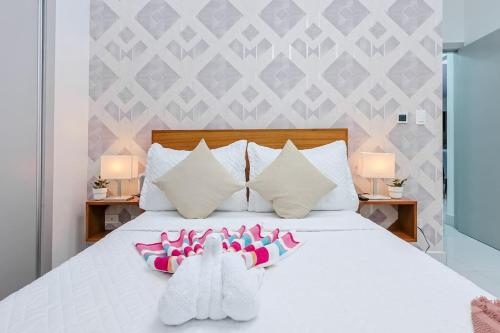 a bedroom with a white bed with two pairs of socks at Upscale Condo, Spectacular Views in Carlos Guerra