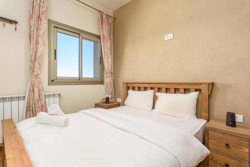 two beds in a bedroom with a window at Lumber's 3-Bedroom House with Garden in Bakish in Qanāt Bakīsh