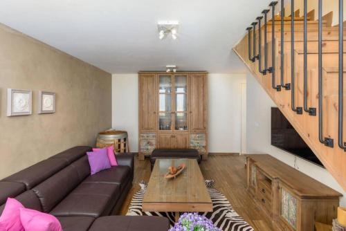 a living room with a couch and a staircase at Lumber's 3-Bedroom House with Garden in Bakish in Qanāt Bakīsh