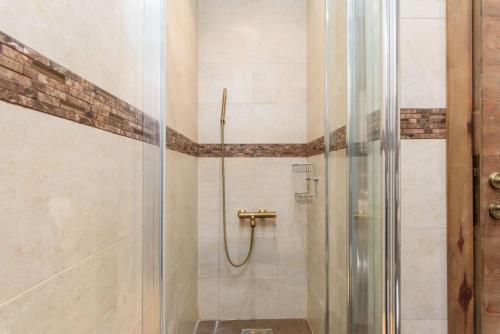 a shower with a glass door in a bathroom at Lumber's 3-Bedroom House with Garden in Bakish in Qanāt Bakīsh