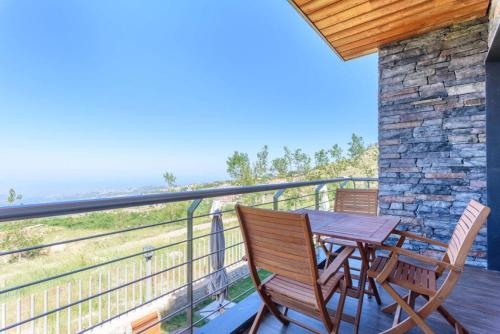 a deck with a table and chairs on a balcony at Lumber's 3-Bedroom House with Garden in Bakish in Qanāt Bakīsh