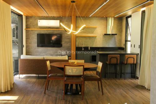 a dining room with a table and chairs and a couch at Igaratá: refúgio em meio a natureza com piscina in Igaratá