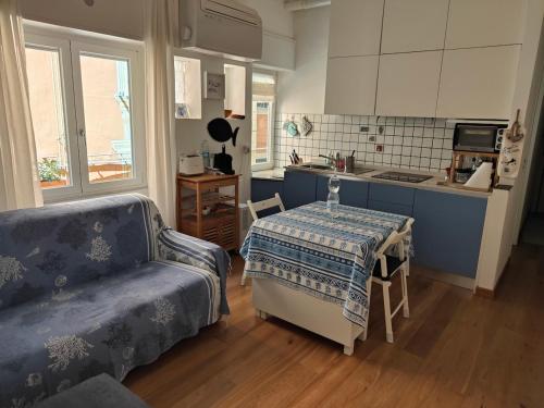 una cucina con un tavolo e un divano in una stanza di Bilocale Nel Centro Storico a Rapallo