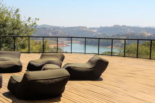 a deck with two lounge chairs on a wooden deck at Igaratá: refúgio em meio a natureza com piscina in Igaratá