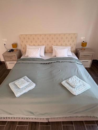a large bed with two tables and two towels on it at Sárffy Vendégház in Szőce