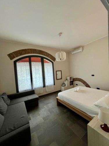 a bedroom with a large bed and a couch at Casa Gien in Ferrara