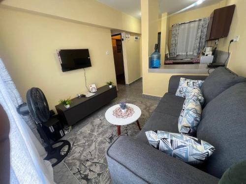 een woonkamer met een bank en een tv bij The R&M Escapes in Kisumu