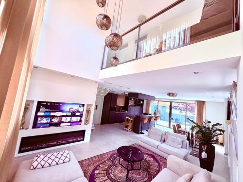 a living room with white furniture and a large tv at Spectacular 3Floor Town House Nearby CityCenter in Rotterdam
