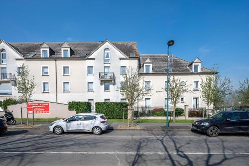 two cars parked in a parking lot in front of a building at Le Délicat - Cozy - Disney 5min - Free Parking in Magny-le-Hongre
