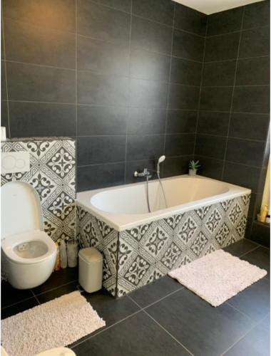 a bathroom with a bath tub and a toilet at Spectacular 3Floor Town House Nearby CityCenter in Rotterdam
