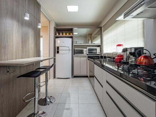 a kitchen with a white refrigerator and a counter at Melhor Apartamento centro Pomerode, perto de tudo in Pomerode