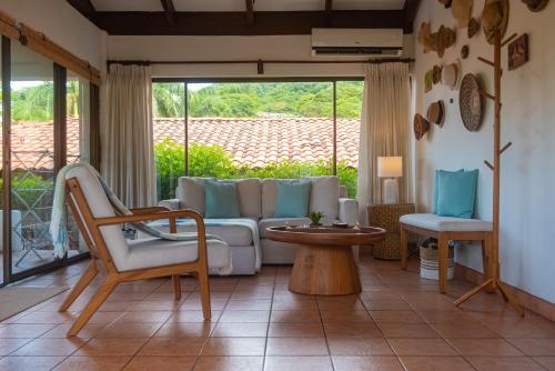 a living room with a couch and a table and chairs at Casa de Encanto Tropical Villa in Playa Hermosa