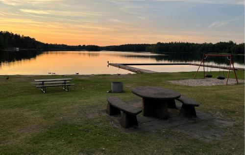 a bench and a picnic table next to a lake at 2 Bedroom Lovely Home In Vittsjö in Vittsjö