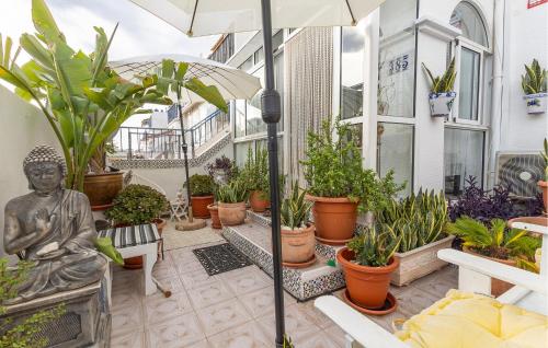 een patio met een standbeeld en veel planten bij Gorgeous Home In Orihuela With Wifi in Villamartin