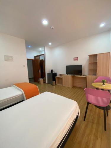 a room with a bed and a table and a tv at July in Lower Princeʼs Quarter