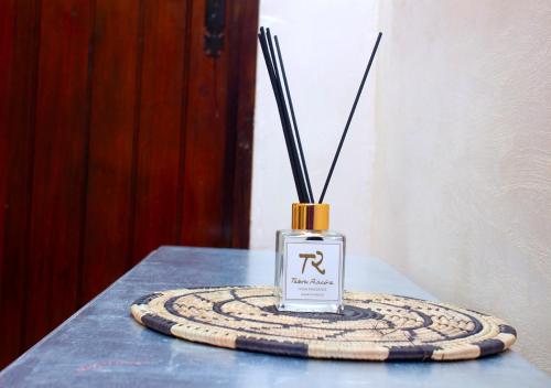 a bottle of perfume sitting on a table at Hôtel La Villa Racine in Dakar