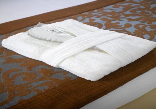 a white towel sitting on top of a wooden table at Hôtel La Villa Racine in Dakar