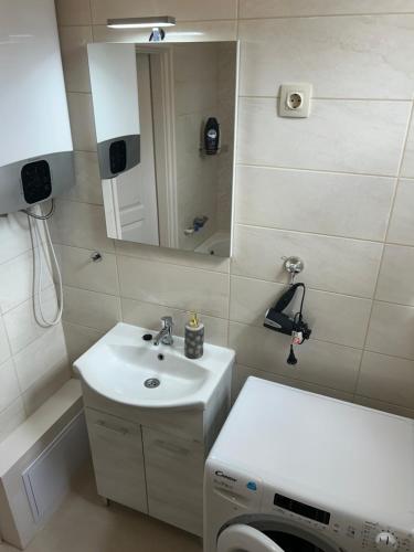 a bathroom with a sink and a mirror at László Apartman in Debrecen