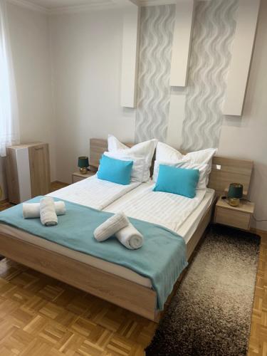 a bedroom with two beds with blue pillows at László Apartman in Debrecen