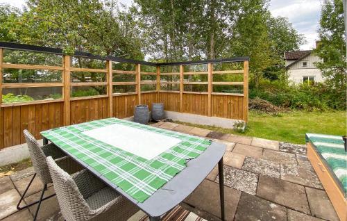 a patio with a table and chairs and a fence at 2 Bedroom Stunning Apartment In Bodafors in Bodafors