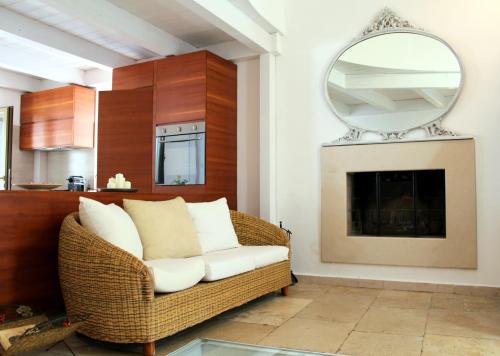 sala de estar con silla de mimbre y espejo en Urban Nest Suite, en Bari