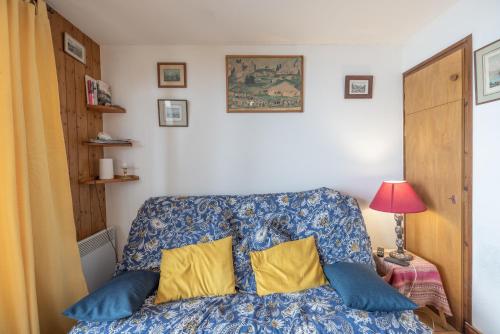 a bedroom with a bed with blue and yellow pillows at Face au Mont Blanc, plein sud in Cordon