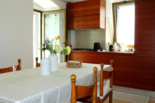 Una cocina con una mesa con un jarrón de flores encima. en Urban Nest Suite, en Bari